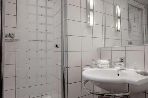 uma casa de banho branca com um lavatório e um chuveiro em DoubleTree by Hilton Bristol City Centre em Bristol