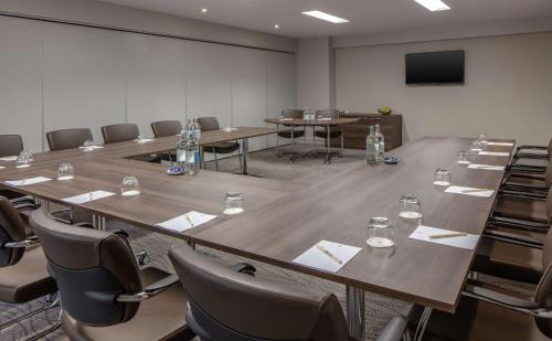 a conference room with tables and chairs and a screen at DoubleTree by Hilton Bristol City Centre in Bristol