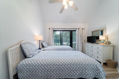 um quarto com 2 camas e uma cómoda e uma janela em 144 High Hammock Villa em Seabrook Island