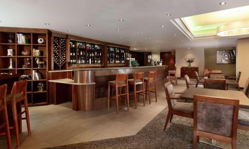 a restaurant with a bar with wooden tables and chairs at DoubleTree by Hilton Bristol City Centre in Bristol