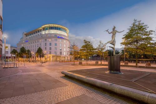 une statue devant un grand bâtiment dans l'établissement Hilton Cardiff, à Cardiff
