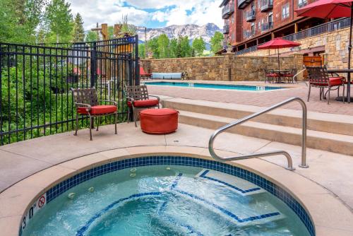 un bain à remous dans une terrasse avec une piscine dans l'établissement Bear Creek Lodge 309B Hotel Room, à Telluride