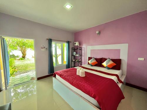 1 dormitorio con paredes moradas y 1 cama con sábanas rojas en Ava Beach Pakbara, en Ban Pak Ba Ra