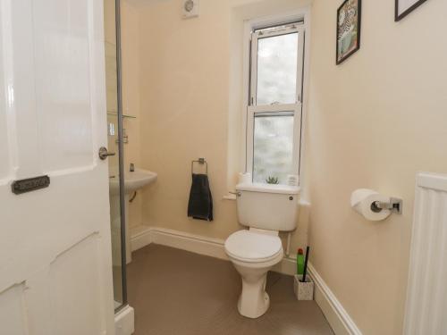 baño con aseo y lavabo y ventana en 5 Tai Isa, en Barmouth