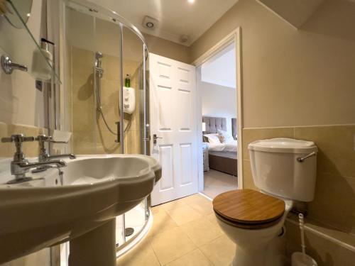 La salle de bains est pourvue d'un lavabo, de toilettes et d'une douche. dans l'établissement Geltsdale East Wing sleeps 6 with River Eden views near Carlisle & Ullswater, à Wetheral