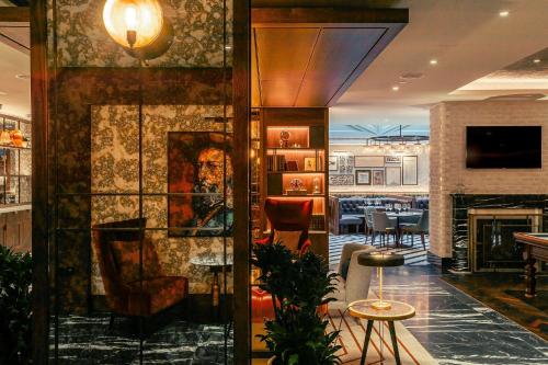 a lobby of a restaurant with a fireplace at The Fellows House Cambridge, Curio Collection By Hilton in Cambridge