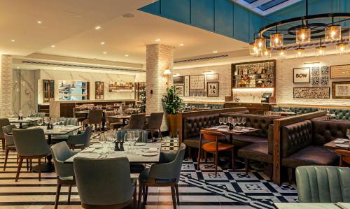 a restaurant with tables and chairs and a bar at The Fellows House Cambridge, Curio Collection By Hilton in Cambridge