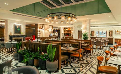 a restaurant with tables and chairs and a bar at The Fellows House Cambridge, Curio Collection By Hilton in Cambridge