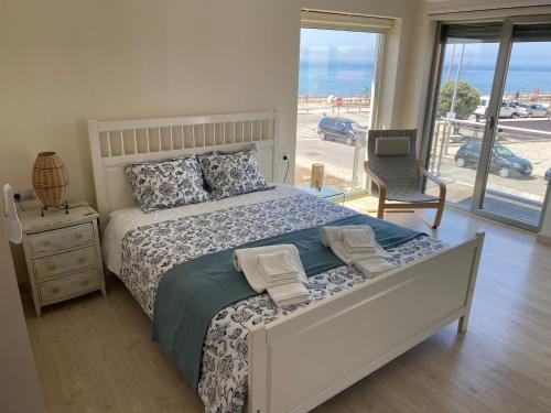 ein Schlafzimmer mit Bett und Blick auf das Meer in der Unterkunft Angeiras Beach House - Porto - Villa by the Sea in Lavra