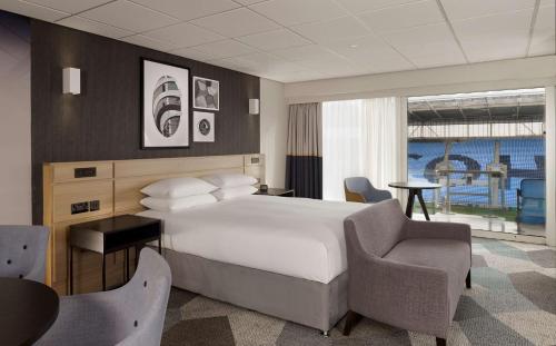 a hotel room with a bed and a chair at DoubleTree by Hilton Coventry Building Society Arena in Coventry