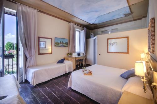 una camera d'albergo con due letti e una finestra di Hotel Villa Liberty a Pontecurone