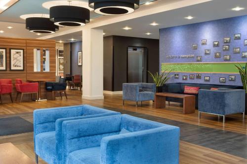 a lobby with blue chairs and a waiting room at Hampton by Hilton York in York