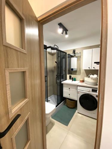 een badkamer met een douche, een toilet en een wastafel bij HB Cozy Home - Przytulne Mieszkanie 