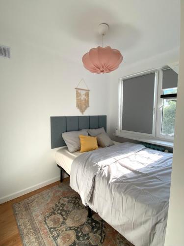 een slaapkamer met een bed en een raam bij HB Cozy Home - Przytulne Mieszkanie 