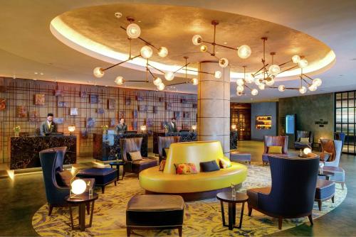 a hotel lobby with a yellow couch and chairs at Hilton London Bankside in London