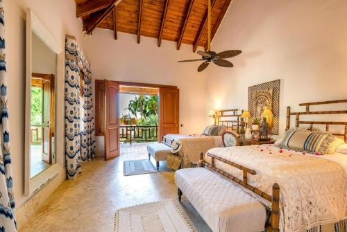 sypialnia z 2 łóżkami i wentylatorem sufitowym w obiekcie Sunny Vacation Villa No 71 w mieście San Rafael del Yuma