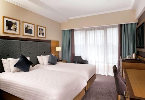 a hotel room with a large bed and a window at DoubleTree by Hilton London Victoria in London