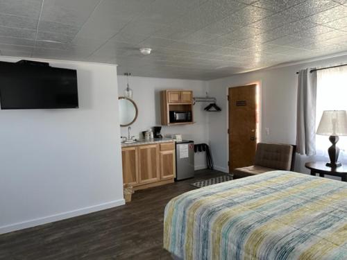 a hotel room with a bed and a kitchen at Lamplighter Lodge in Panguitch