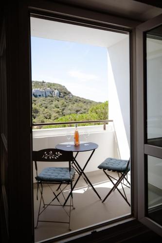une table et deux chaises sur un balcon avec vue dans l'établissement studio meublé vue exceptionnelle, aux Baux-de-Provence