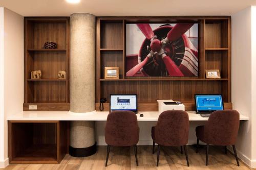 a desk with two laptops on it in a room at Hampton By Hilton London Stansted Airport in Stansted Mountfitchet