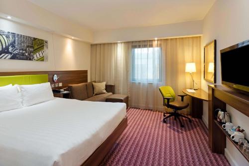 um quarto de hotel com uma cama grande e uma secretária em Hampton by Hilton London Croydon em Croydon