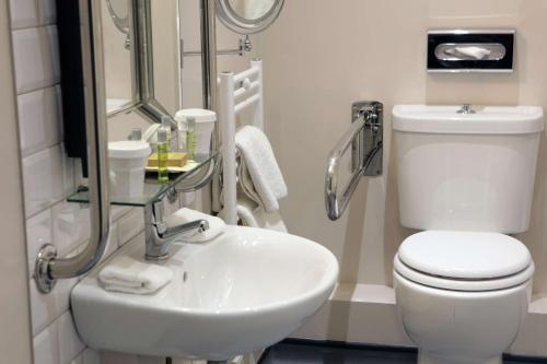 a bathroom with a white toilet and a sink at DoubleTree by Hilton York in York