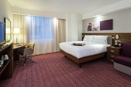 Habitación de hotel con cama, escritorio y TV. en Hampton by Hilton London Gatwick Airport, en Horley