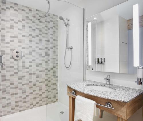 a bathroom with a sink and a shower at Hampton by Hilton Glasgow Central in Glasgow