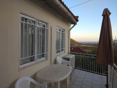a table and chairs on a balcony with a view at Vintage House with a fantastic view in Mavrommátion