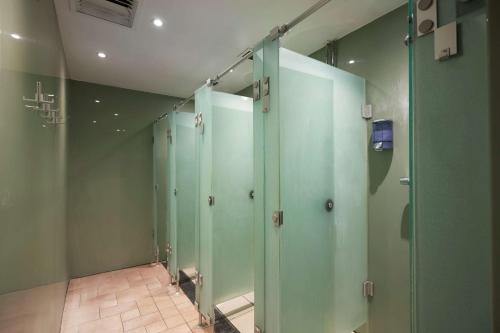 a row of green stalls in a bathroom at DoubleTree by Hilton Dartford Bridge in Dartford