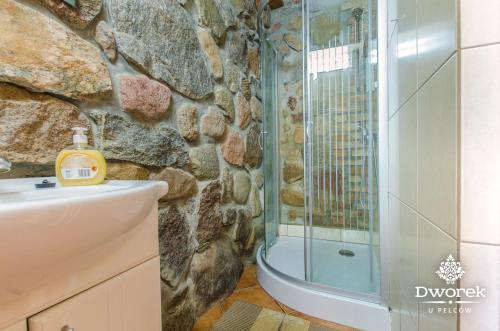 La salle de bains est pourvue d'une douche et d'un lavabo. dans l'établissement Agroturystyka "Dworek u Pelców", à Ryn
