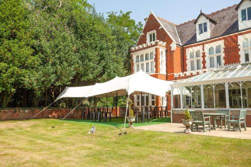 a white tent in front of a house at DoubleTree by Hilton St. Anne's Manor in Bracknell