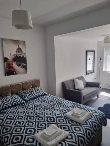 a bedroom with a bed and a couch and a chair at Bob's Bunkhouse in Troed-y-rhiw