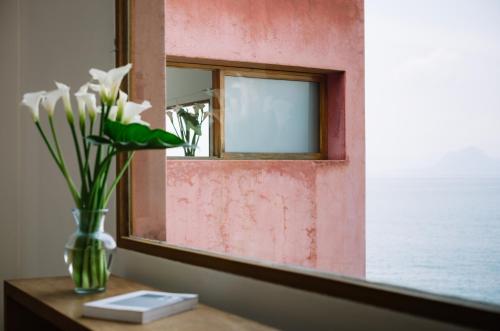 un jarrón de flores en una mesa frente a un espejo en Anzan Atitlan, en San Marcos La Laguna