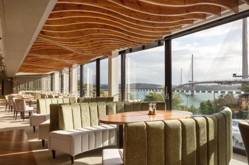 een restaurant met een tafel en stoelen en een groot raam bij DoubleTree by Hilton Edinburgh - Queensferry Crossing in North Queensferry