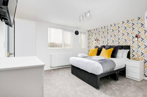 a bedroom with a king sized bed with yellow pillows at SCA - Luxurious Studio - VS5 in Wolverhampton