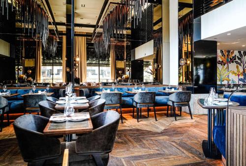 a restaurant with tables and chairs and a bar at Hilton The Hague in The Hague