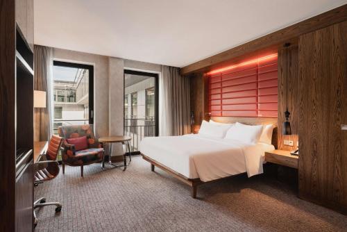 Schlafzimmer mit einem Bett, einem Schreibtisch und einem Stuhl in der Unterkunft Hilton The Hague in Den Haag
