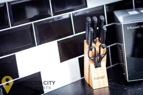 a knife block with four pairs of scissors next to a microwave at SCA - Perfect City Studio - VS7 in Wolverhampton