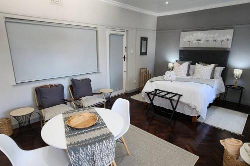 a bedroom with a bed and a table and chairs at Ebenezer in Somerset West