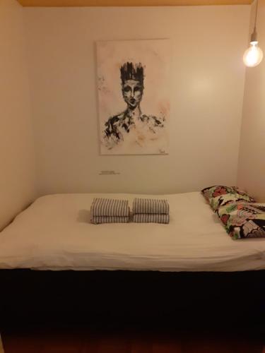 1 cama en una habitación con un cuadro en la pared en Ann's terraced house with sauna en Vantaa