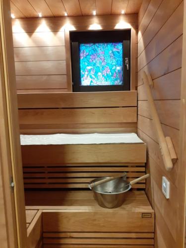 a sauna with a bowl and a television in it at Ann's terraced house with sauna in Vantaa