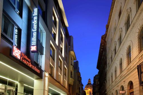oświetlony znak na boku budynku w obiekcie Hilton Garden Inn Budapest City Centre w Budapeszcie