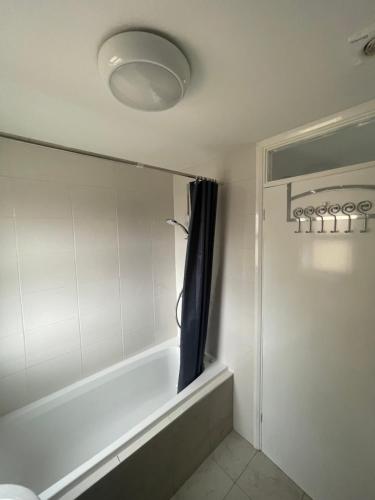 La salle de bains est pourvue d'une baignoire avec rideau de douche. dans l'établissement Home away from home, à Peterborough