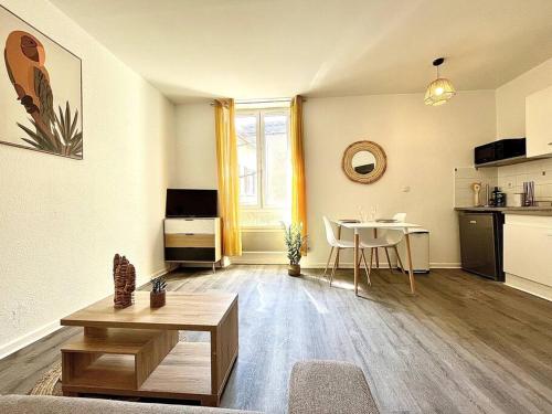 un salon avec une table et une cuisine dans l'établissement La Topaze Jaune - Romans, à Romans-sur-Isère