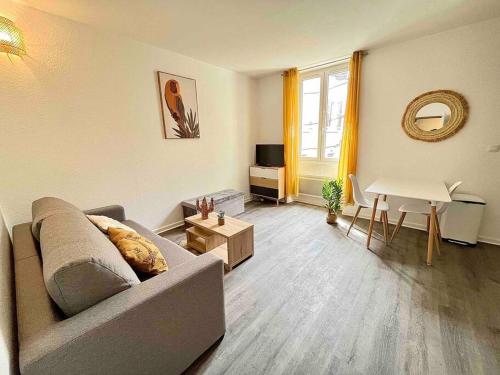 un salon avec un canapé et une table dans l'établissement La Topaze Jaune - Romans, à Romans-sur-Isère