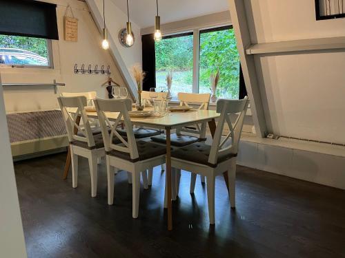 a dining room with a white table and chairs at Chalet 177 Durbuy in Durbuy