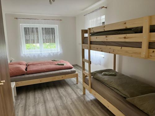 een slaapkamer met 2 stapelbedden en een raam bij Kozákov Apartmány - první patro 