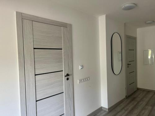 een witte deur in een kamer met een spiegel bij Kozákov Apartmány - první patro 