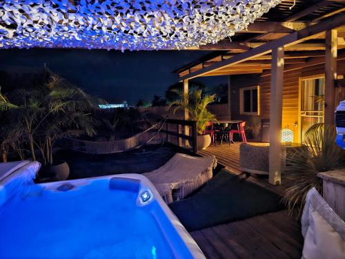 a patio with a hot tub on a deck at night at Zimmer spa in megadim in Bet Ẕevi